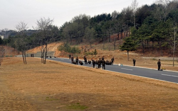 Les soldats s'activent pour embellir la route qu'utilisera le convoi des officiels 